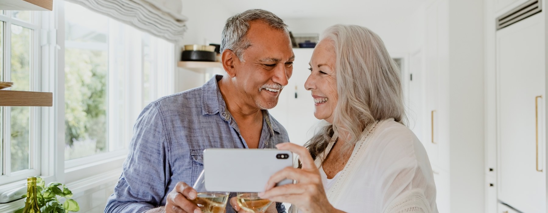 a man and a woman holding a phone and smiling