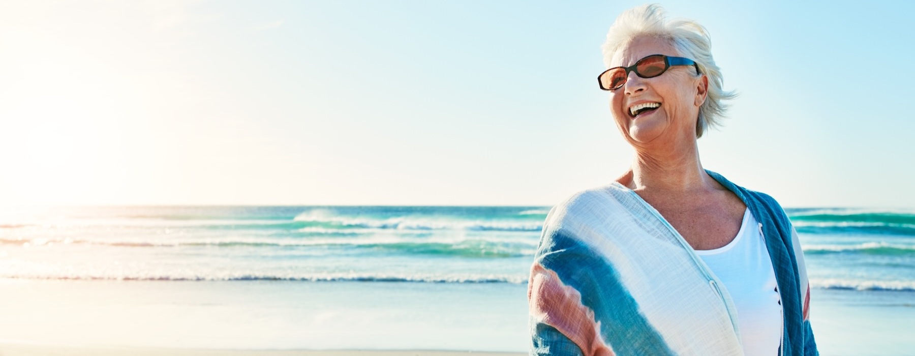 a woman smiling at a beach