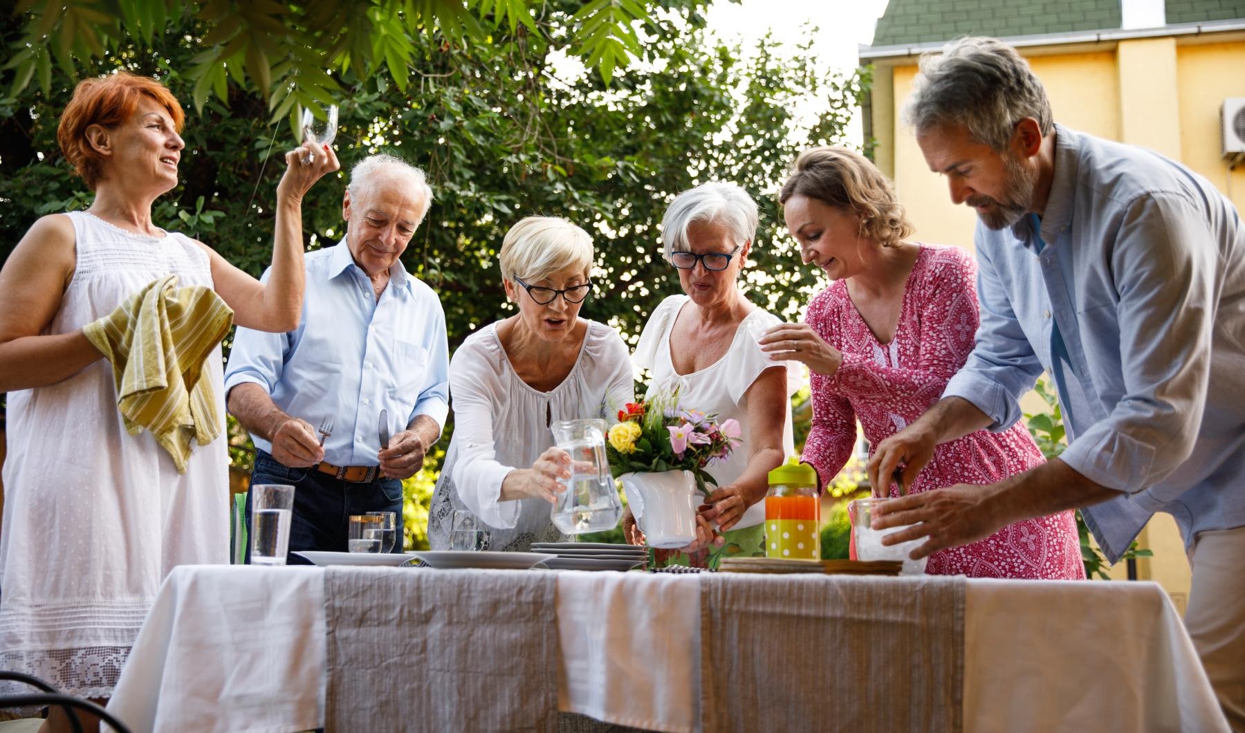a group of people standing around a table with flowers