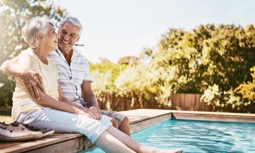 a man and woman sitting by a pool